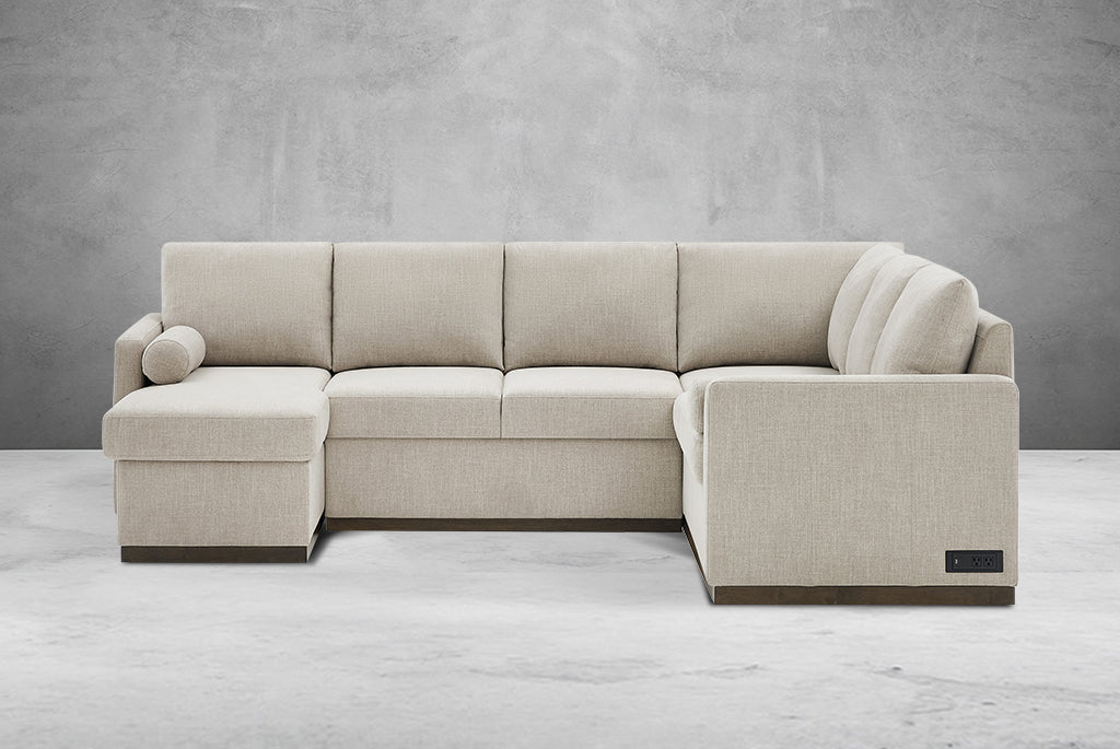 Beige Element Full-Size Sleeper Sectional with Storage Chaise against a gray concrete wall