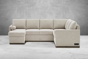 Beige Element Full-Size Sleeper Sectional with Storage Chaise against a gray concrete wall