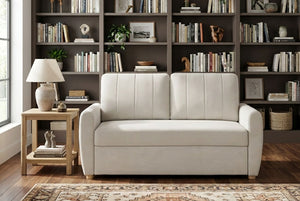 Beige Coddle sofa in a room with bookshelves and a lamp
