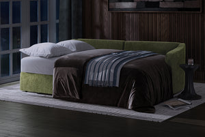 Green Matrix Queen-Sized Sleeper Sofa with brown blanket and striped throw in a dimly lit room