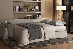 Light gray Matrix Queen-Sized Sleeper Sofa in a room with a bookshelf and lamp