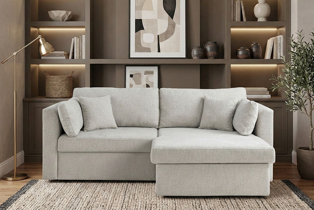 Nova Full-Size Sleeper Sectional in a living room with bookshelves and decor.